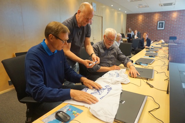 Taiteilija Anders Petersen (kesk.) sai paitaansa Karppisen nimikirjoituksen.