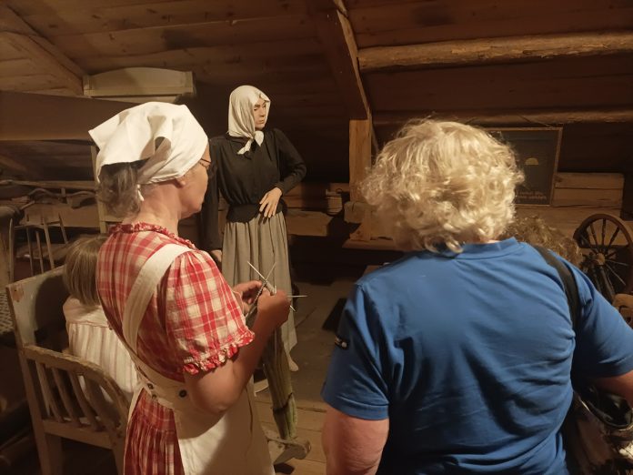 Tarvasjoen kotiseutumuseon sukkaa kutova opas Varsinais-Suomen museopäivänä vuonna 2024. Kuva: Liedon museo.