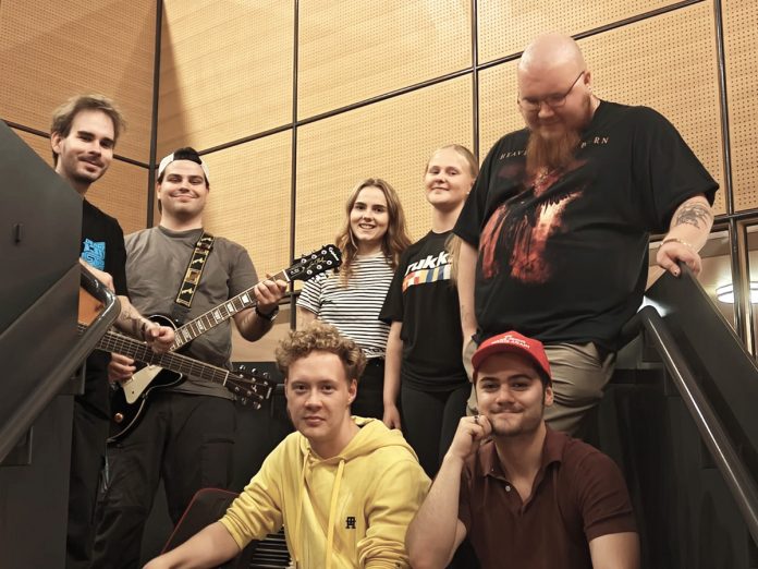 Gospeliako-bandi web kuva Miika Silvennoinen Gospeliako? -projektibändi vas.: Juuso Kärkkäinen (kitara), Iiro Pääkkönen (kitara & laulu), Senni Kärkkäinen (laulu), Anna Peravina (laulu) ja Atte Lehto (basso & laulu). Edessä vas.: Johannes Salovaara (koskettimet) ja Emre Pir (rummut). Kuva: Miika Silvennoinen.