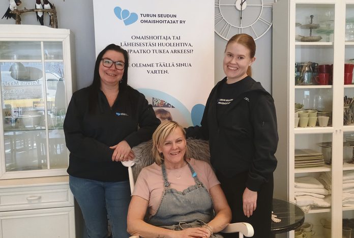 Turun Seudun Omaishoitajat ry:n projektityöntekijä Jonna Korhonen sekä digitoiminnan ja Ovet-valmennuksen ohjaaja Katariina Oso Cafe Akselin yrittäjä Eija Lehtimäen (keskellä) kanssa. Kuva: Katariina Mäkinen-Önsoy.