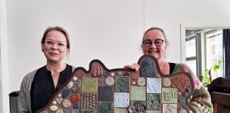 Sauvon koulukeskuksen ruokasaliin savireliefi Sauvon Käsien Erja-Riitta Alander ja Nina Messner esittelevät savireliefiä. Kuva: Julia Ojala, Sauvon kunnan viestintäharjoittelija.